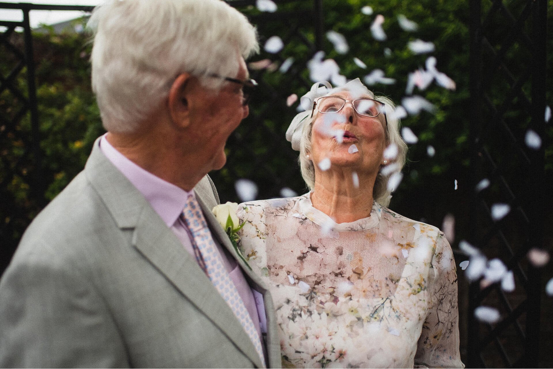 An older couple laughing in a shower of confetti