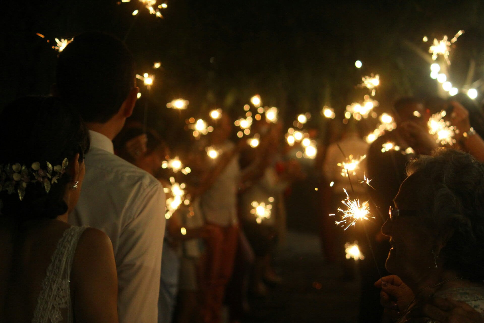 Guests holding sparklers after dark