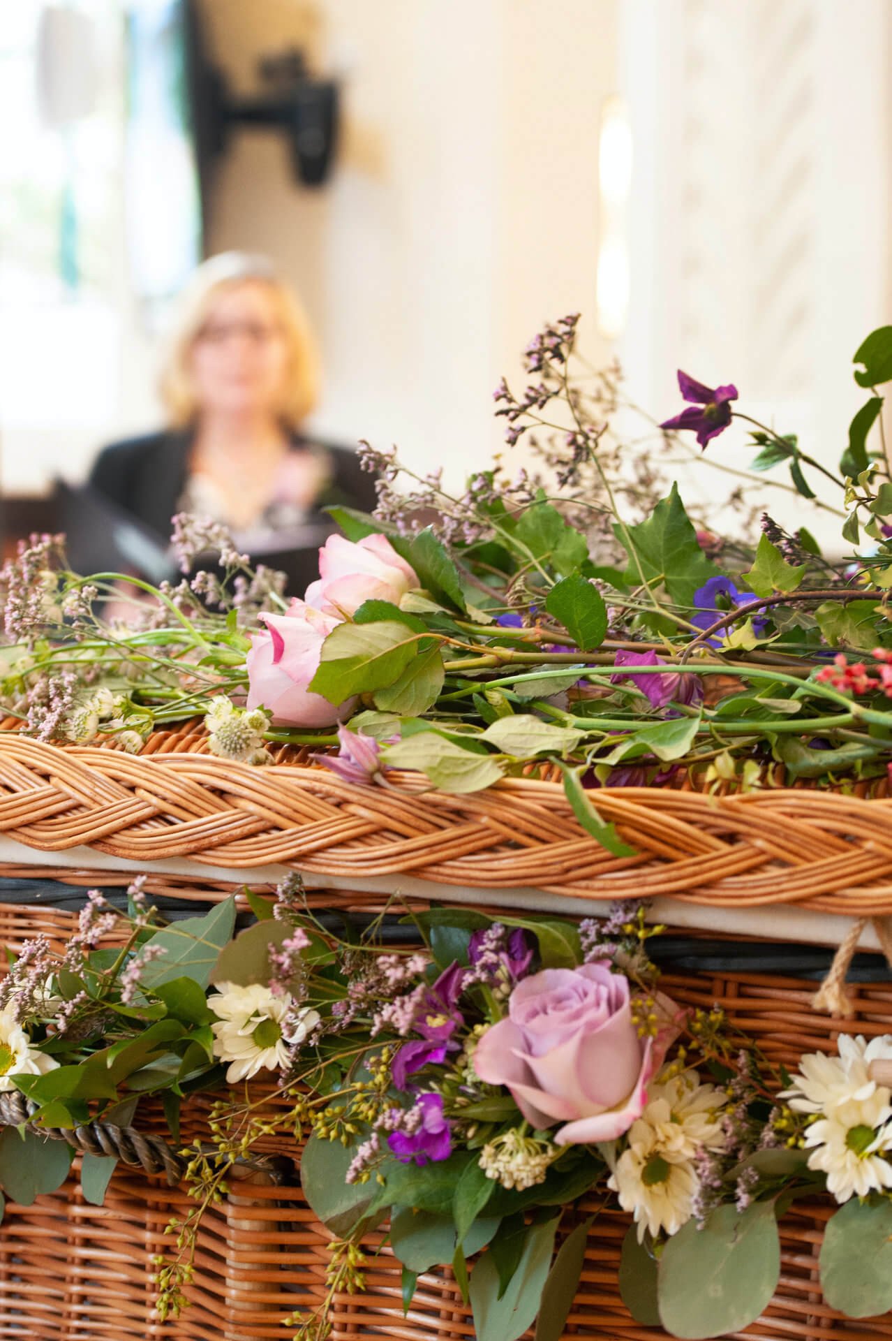 Wildflowers and roses laid the length of a willow coffin